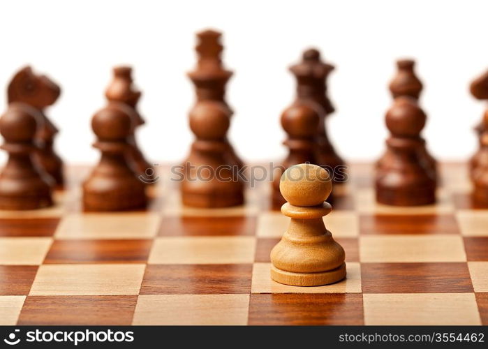 One pawn agains all - wooden chess pieces on chessboard. Selective focus, shallow depth of field