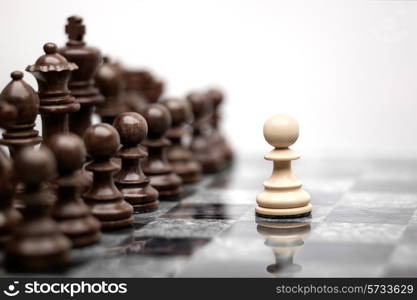 One pawn staying against full set of chess pieces.