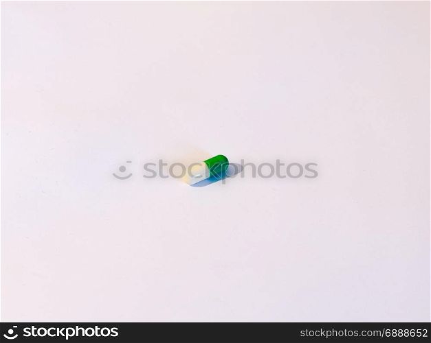one pill on a background of white, a white and green tablet antidepressant drug generic stock photo