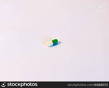 one pill on a background of white, a white and green tablet antidepressant drug generic stock photo