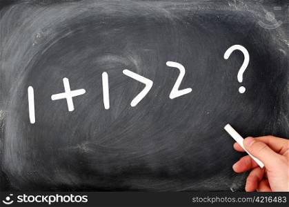 One plus one is greater than two. Question written on a blackboard.
