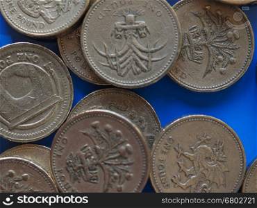 One Pound (GBP) coin, United Kingdom (UK) over blue. Many One Pound (GBP) coins, currency of United Kingdom (UK) over blue background