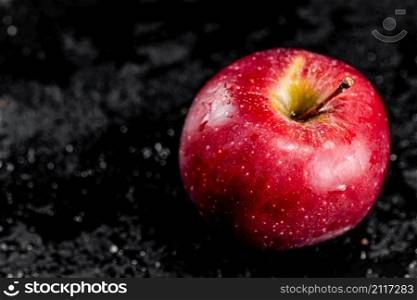 One red apple on the table. On a black background. High quality photo. One red apple on the table.