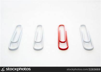 One red paper clip, three white ones.