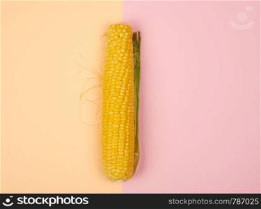 one ripe yellow corn cob on a abstract background, top view, copy space