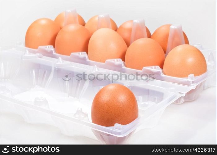 one separate chicken egg against several brown eggs