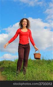 one smiling woman wearing t-shirt and jeans with pottle is walking outdoors.