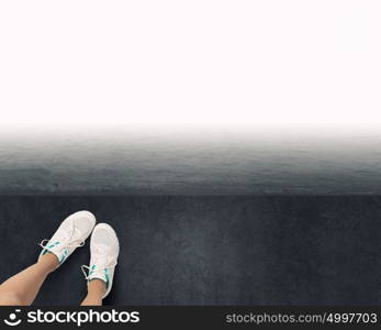 One step to gap. Woman standing on the edge of the roof