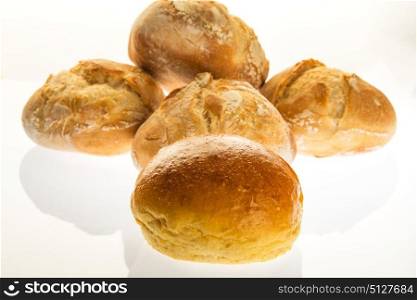 one sweet bread in front of four small bread with round shape made on wood stove