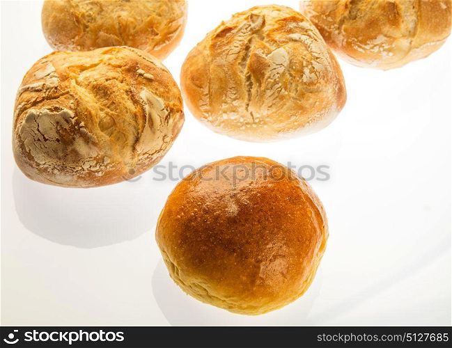 one sweet bread in front of four small bread with round shape made on wood stove