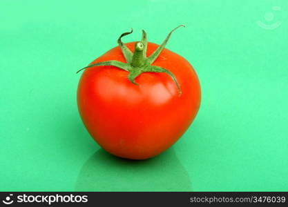 one tomato on green background