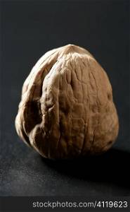 One walnut with shells over black background