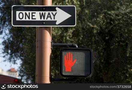 One Way Sign Next to Pedestrian Crosswalk Signal