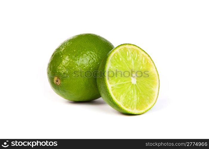 One whole lime and one half lime isolated on a white background