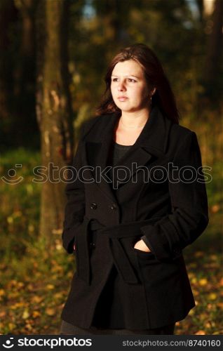 One Woman outdoors wearing black coat autumn park