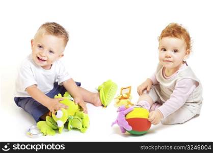 One year old babies (a boy and a girl) enjoy playing with toys. Studio Shot. All toys visible on the photo are officialy property released.