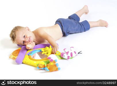 One year old baby boy enjoys playing with toys. Studio Shot. All toys visible on the photo are officialy property released.