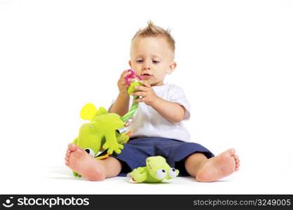 One year old baby boy enjoys playing with toys. Studio Shot. All toys visible on the photo are officialy property released.