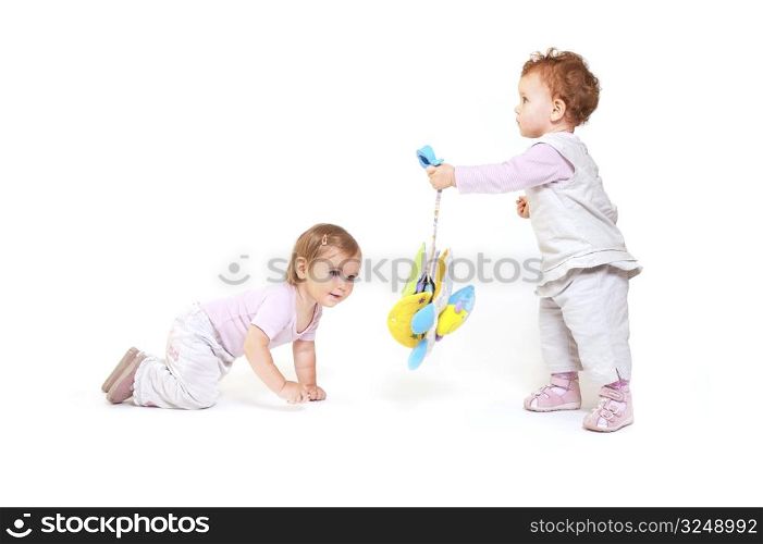 One year old baby girls enjoy playing with toys. Studio Shot. All toys visible on the photo are officialy property released.
