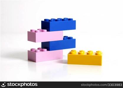 One yellow block and a stack of blue and pink ones.