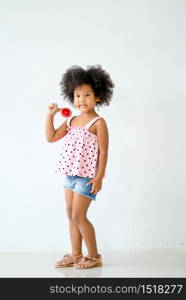 One young African girls enjoy with dancing in front of white wall and smile.