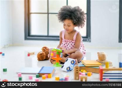 One young African little girls play toys and look fun and enjoy in living room with day light.
