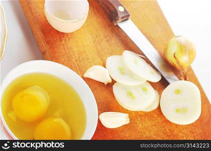 Onion, garlic and egg. Spicery on cutting board