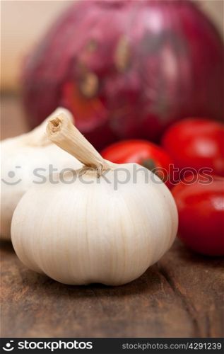 onion garlic and tomatoes foundations of Italian food on rustic table
