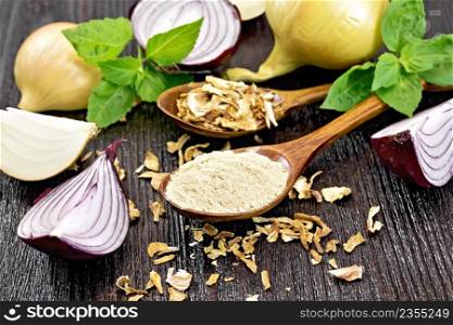 Onion powder and dried flakes in two spoons, purple and yellow onions, fresh basil on wooden board background
