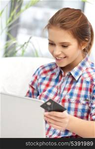 online and internet shopping concept - happy teenage girl with laptop and credit card