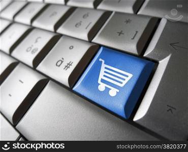 Online e-shopping concept with basket icon and symbol on a blue laptop computer key for Internet website and on line business.