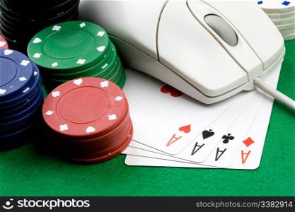 Online gaming and gambling concept, green felt, a mouse, cards and casino chips