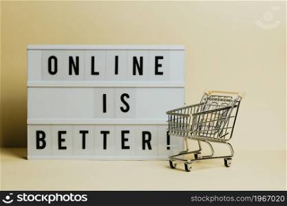 Online is better sign, commercial shot, e-commerce concept, shop cart with a pastel yellow background, copy space and minimal styling