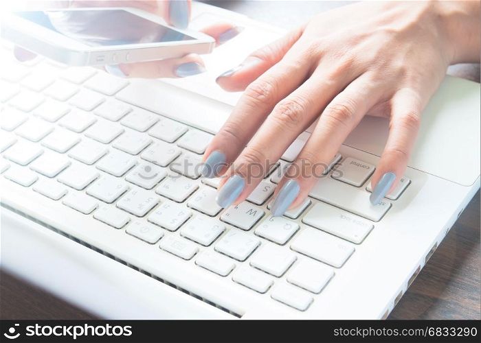 Online marketing concept with woman hand using mobile device and laprop computer