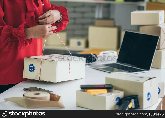 Online seller works at home office and packs shipping delivery box to customer. Small business owner or entrepreneur doing e-commerce business on the internet.