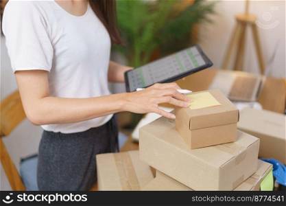 Online selling concept, Asian business women is checking products for prepare delivery to customer.