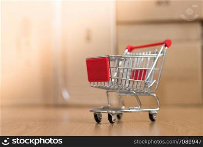 Online-Shopping and parcel service concept: Miniature shopping cart and cardboard boxes