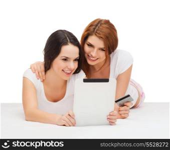 online shopping and technology concept - two smiling teenage girls with tablet pc computer and credit card