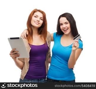 online shopping and technology concept - two smiling teenagers with tablet pc computer and credit card