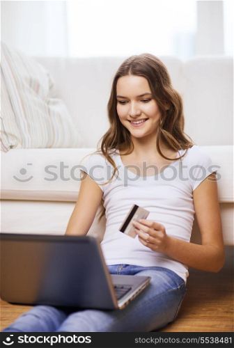 online shopping, banking and technology concept - smiling teenage girl with laptop computer and credit card at home