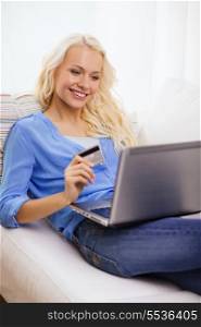 online shopping, banking and technology concept - smiling young woman with laptop computer and credit card