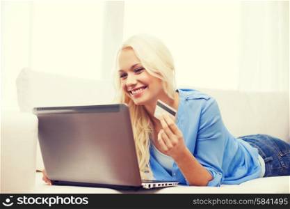online shopping, banking and technology concept - smiling young woman with laptop computer and credit card
