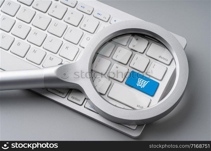 Online shopping & business icon on retro computer keyboard with magnifying glass