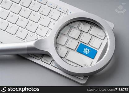 Online shopping & business icon on retro computer keyboard with magnifying glass
