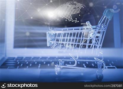 Online shopping concept. Closeup of shopping basket with digital globe and wireless digital line connection symbol on laptop. Business and technology.