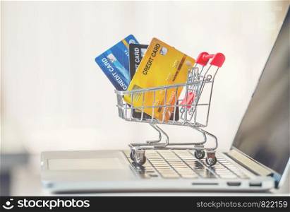 online shopping concept, Shopping cart and credit card with laptop on the desk