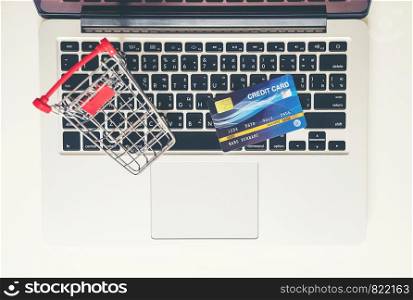 online shopping concept, Shopping cart and credit card with laptop on the desk