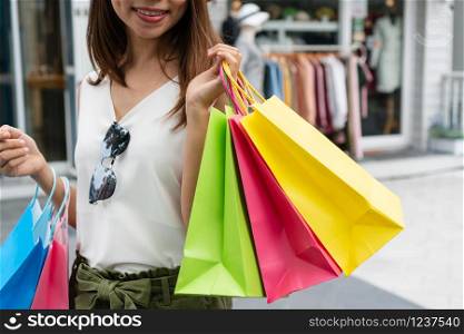 Online shopping concept. Shopping cart, parcel boxes, laptop, credit card, mobile phone on the desk at home. top view, copy space. Concept of happy woman shopping and holding bags, closeup images.