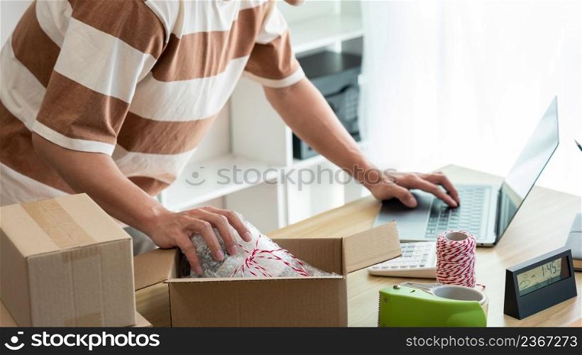 Online shopping concept the product supplier checking the detail on the computer and the real product in the parcel before sending it.