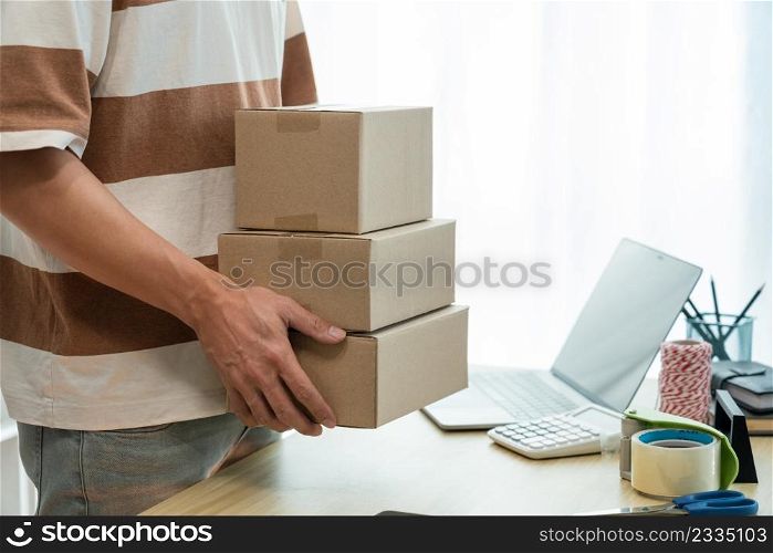 Online shopping concept the seller holding three boxes of his products to post them.